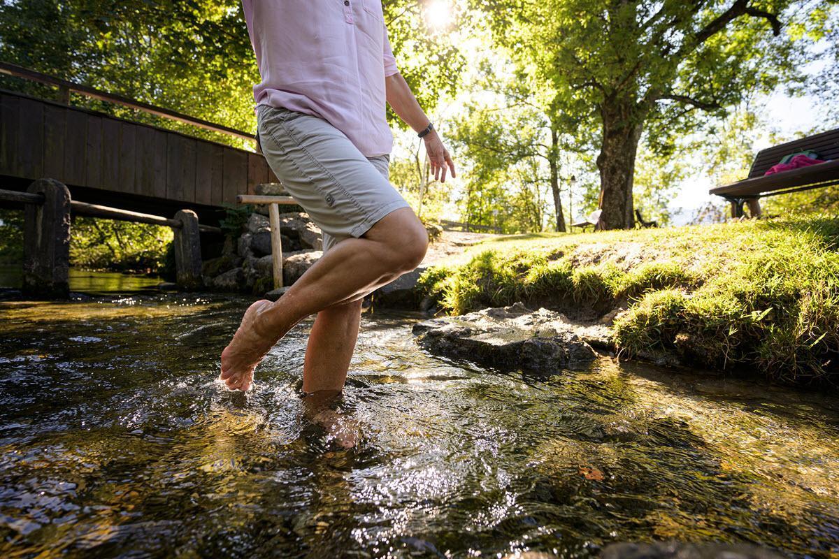 Auf dem Foto sehen Sie einen Mann, der in einem Natur-Kneipp-Trettbecken steht.